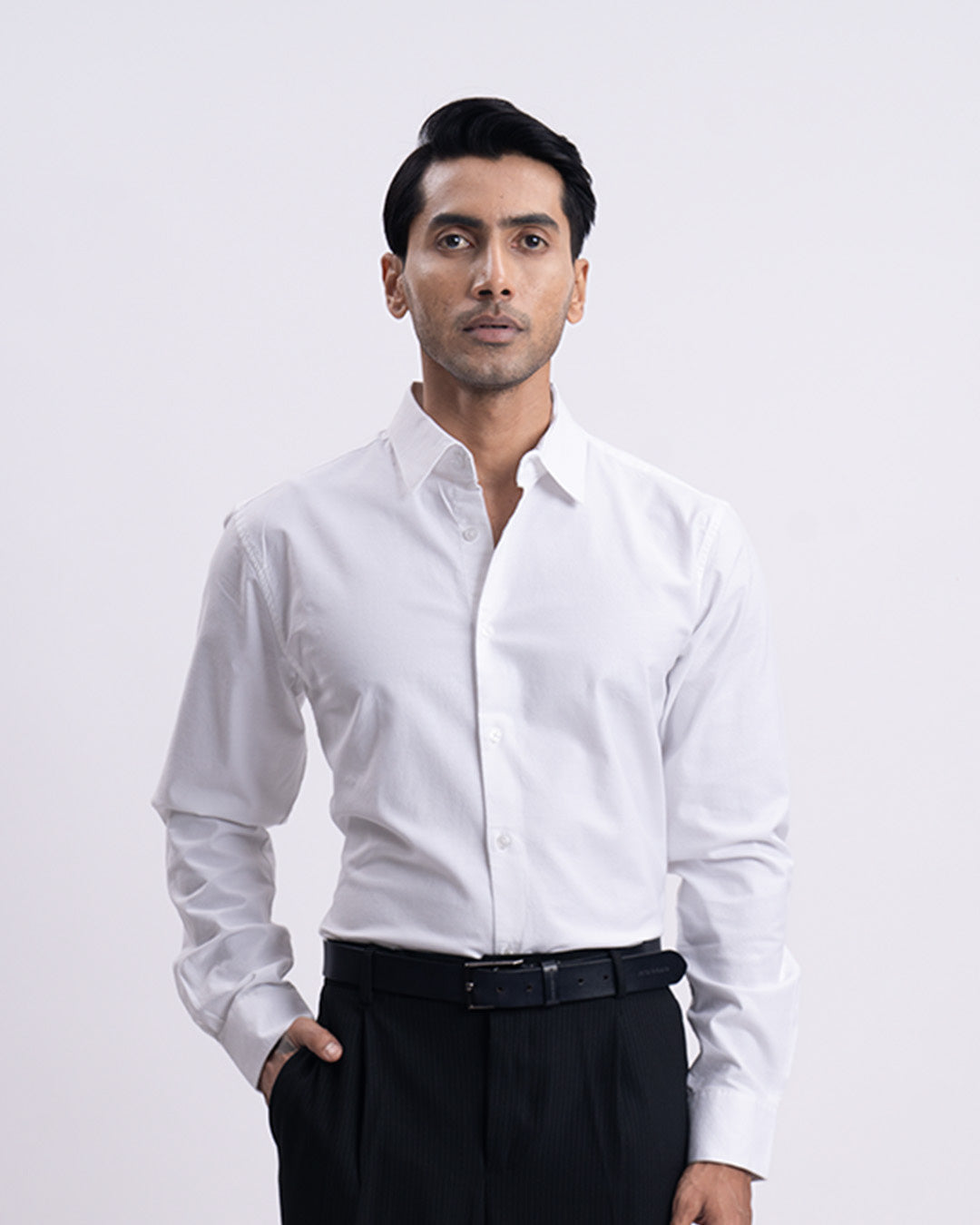 Man wearing a white dress shirt and black pants on a white background