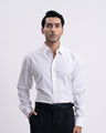 Man wearing a white dress shirt and black pants on a white background