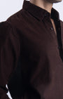 Brown corduroy shirt worn by a person on a white background