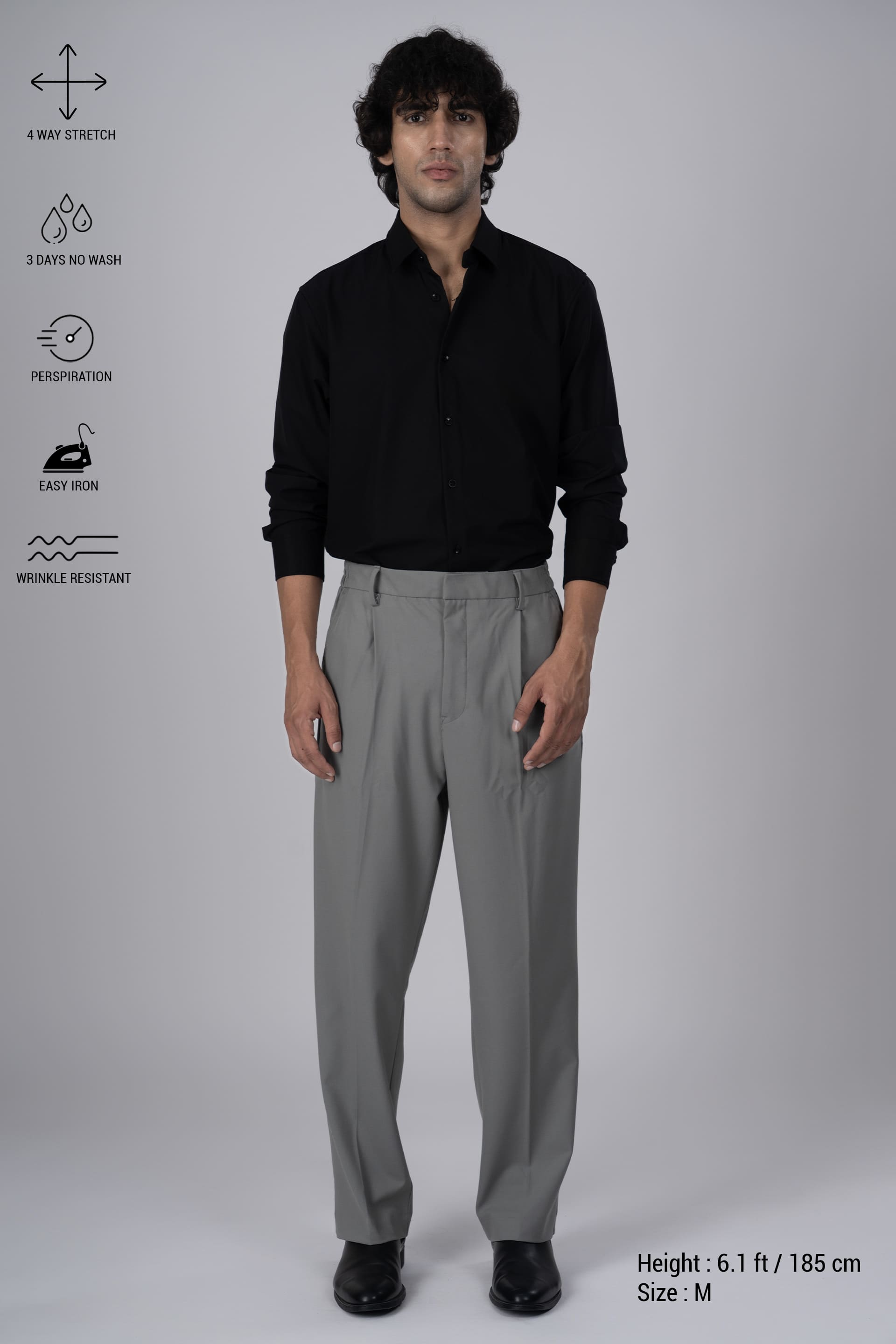 Tailoraedge Easy Iron Relaxed Pleated Trousers In Grey, Full Model Image of the Trousers styled with a Black Shirt and Features and Functions on the left.